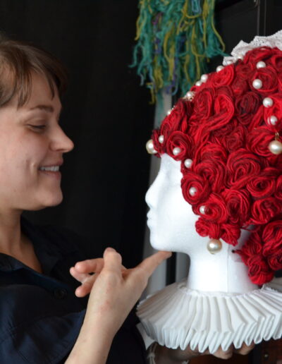Markkanen poseeraamassa kuningatar Elisabethista inspiraatiota otetun peruukin kanssa. Kuva: Suomen käsityön museo / Paju Pelkonen, 2026